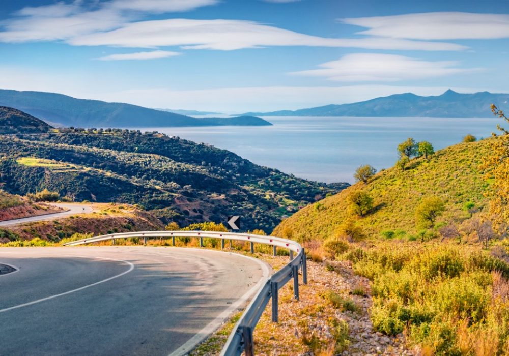 Typical Albanian landscape on the Adriatic shore with empty asphalt road. Bright spring morning in Albania, Europe. Traveling concept background.